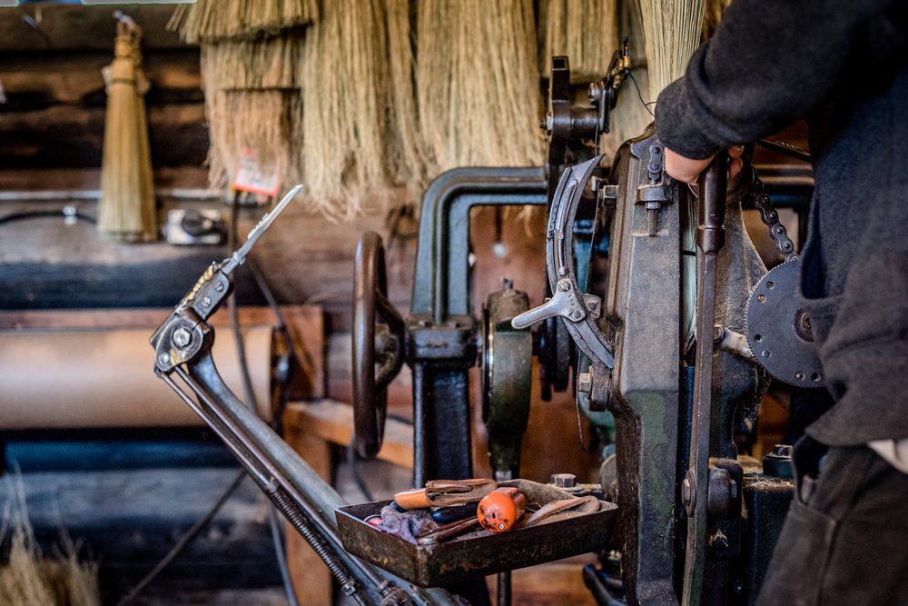 Antique broom-making machinery in the log barn